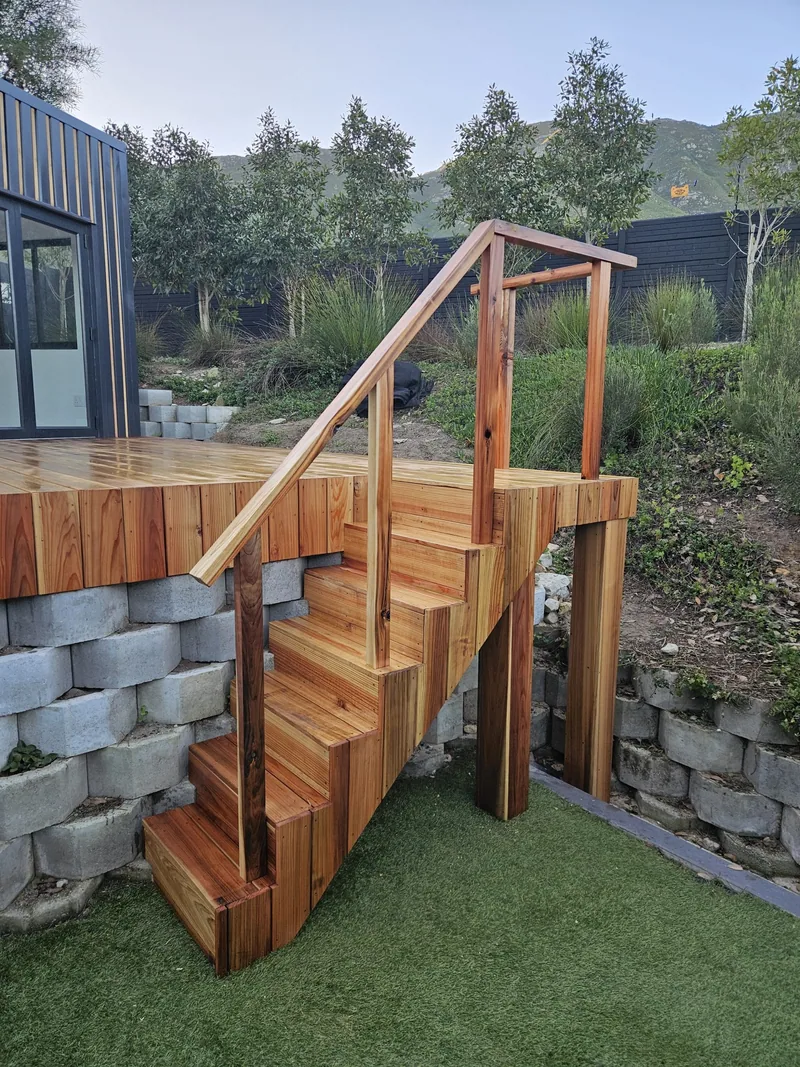 One Bedroom Pod exterior deck stairs with hardwood handrails leading to the raised home