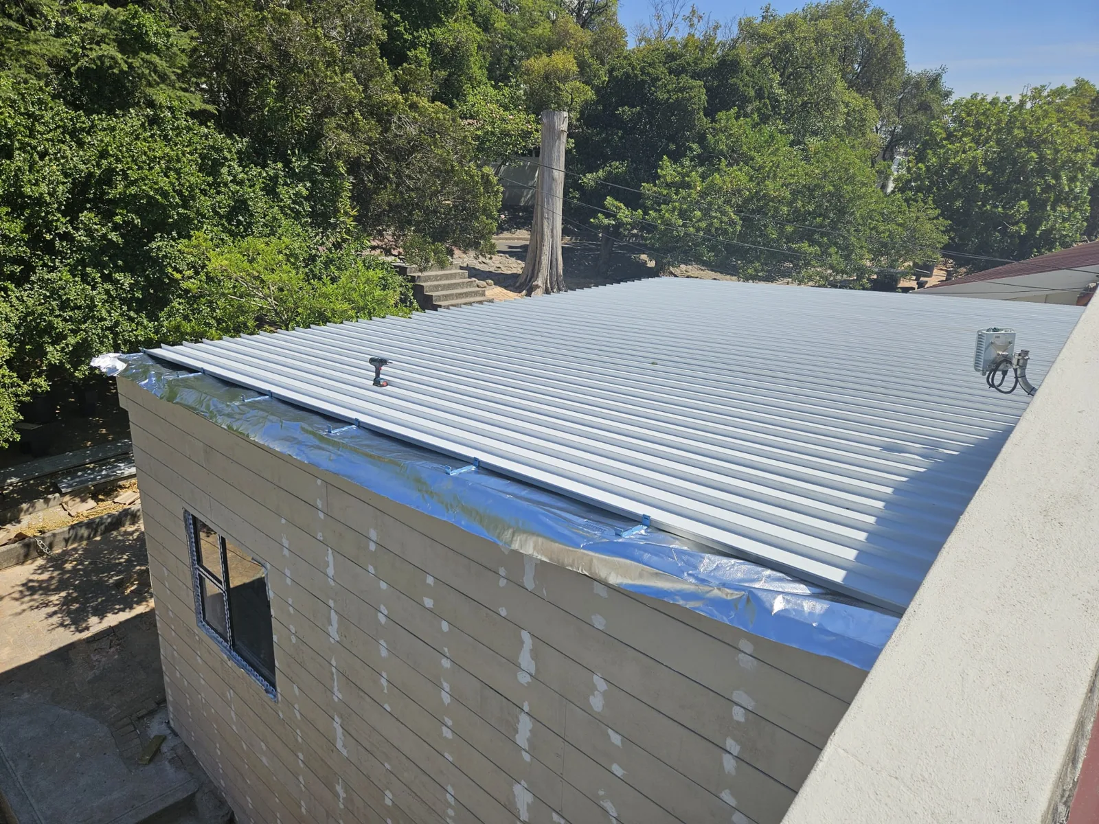 IBR roof sheeting being fixed to the art classroom during construction