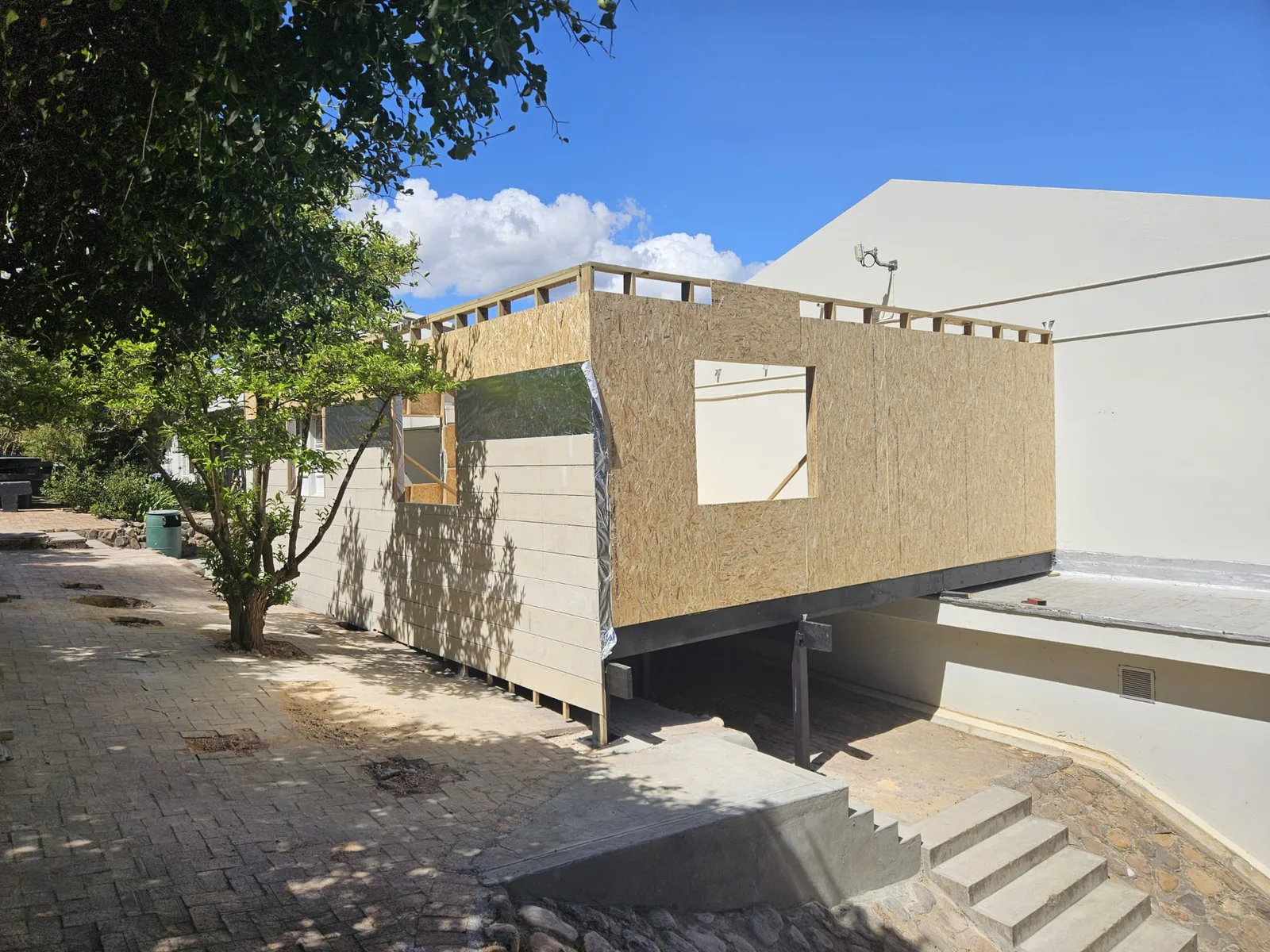 Art classroom structure part-clad, with OSB sheathing and window openings framed
