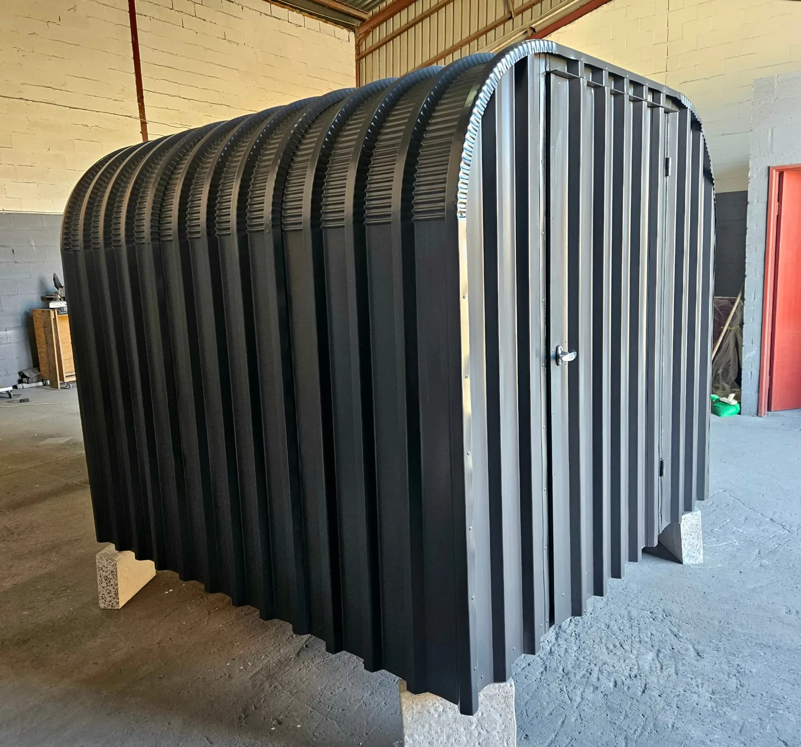 Rear detail of the bike shed showing the curved roof ribs and block supports