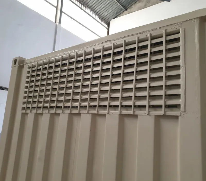 Close view of large louvred ventilation panels fitted into the side of a beige container