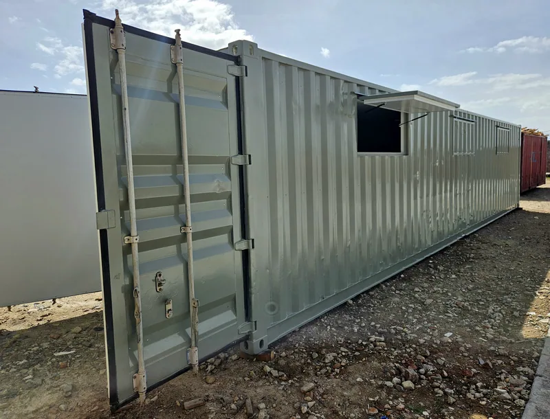Pale green container with an end door open and a hatch opening cut into the side wall