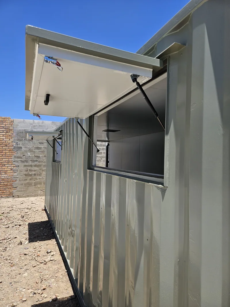 Container with a gas-strut serving hatch propped open, showing the white-lined interior