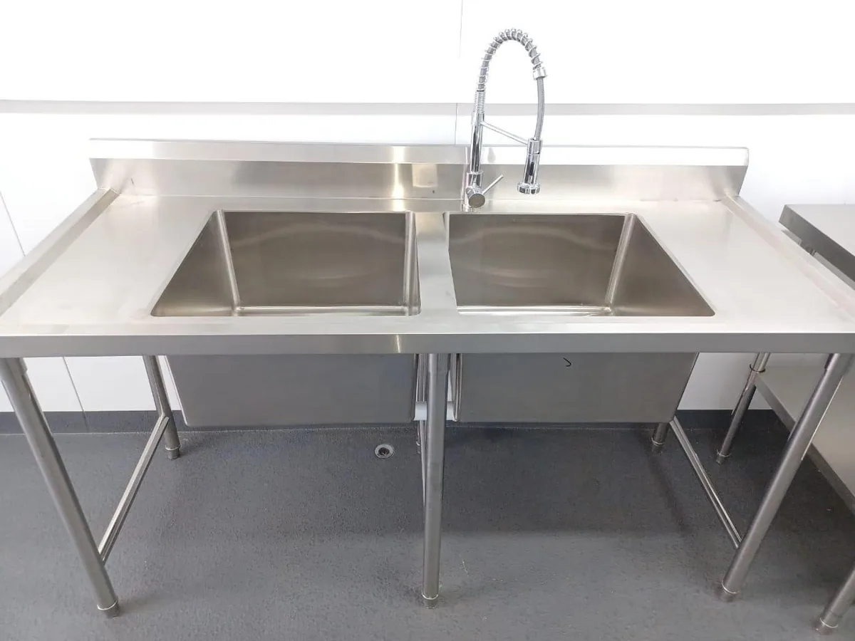 Stainless steel double-bowl sink unit with a spray tap and drainer inside a container kitchen