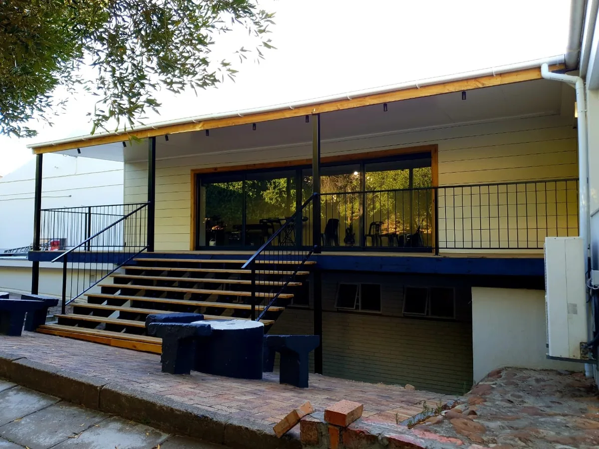 Completed school music room with a raised timber deck, steel balustrade and wide sliding doors under a covered veranda