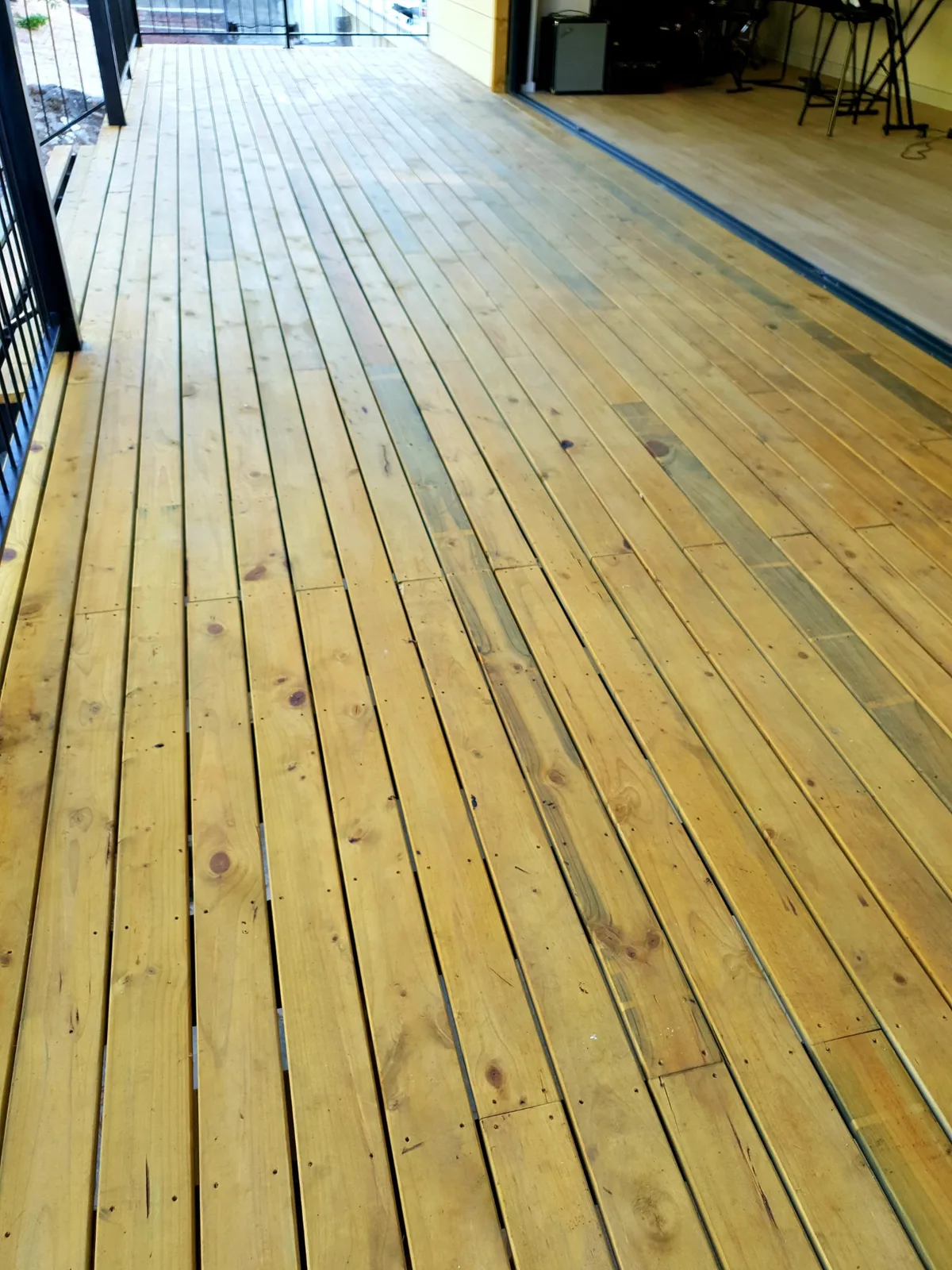 Close view of the timber deck boards leading to the open door threshold of the music room