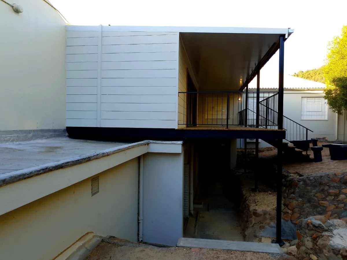 Rear elevation of the music room showing the cantilevered deck over the paved courtyard